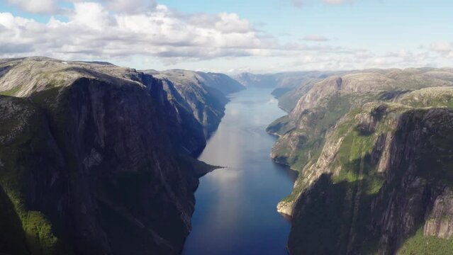 Drone flies in the valley of beautiful Lysefjord Norway with scenic mountains and cliff walls high above the fjord - 4K