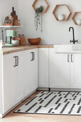 Fototapeta premium Stylish rug with dots on floor in kitchen