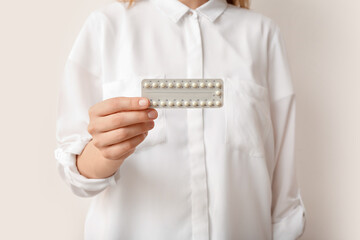 Woman with hormonal pills on white background, closeup