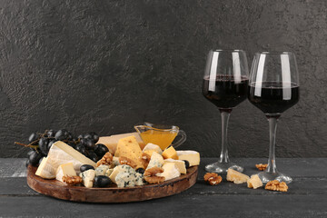 Pieces of tasty cheese, honey, grapes and glasses with wine on table