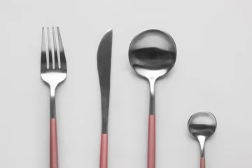 Fotobehang Silver fork, knife and spoons with pink handle on grey background © Pixel-Shot