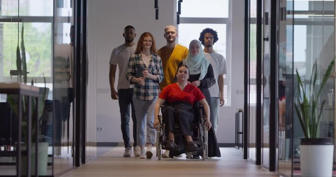 A diverse group of young business people congregates within a modern startup's glass-enclosed office, featuring inclusivity with a person in a wheelchair, an African American young man , and a hijab