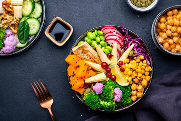 Vegan buddha bowl with sweet potato, quinoa, chickpeas, soybeans edamame, tofu, corn, cabbage, radish, broccoli and seeds, black table background, top view. Autumn or winter healthy vegetarian food - obrazy, fototapety, plakaty