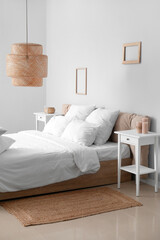 Interior of modern bedroom with comfortable double bed, white pillows and wicker lamp