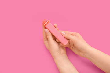 Woman holding electronic cigarette on pink background