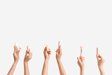 Women with makeup products on white background