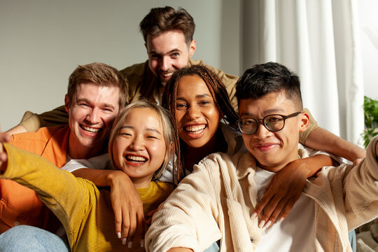 multiracial group of young friends smiling and taking selfies for the camera, asian, african american and european