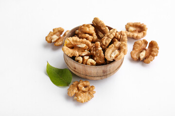 Bowl of tasty walnuts on white background