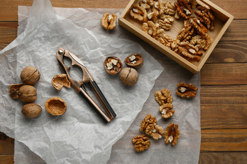 Box of tasty walnuts on wooden background