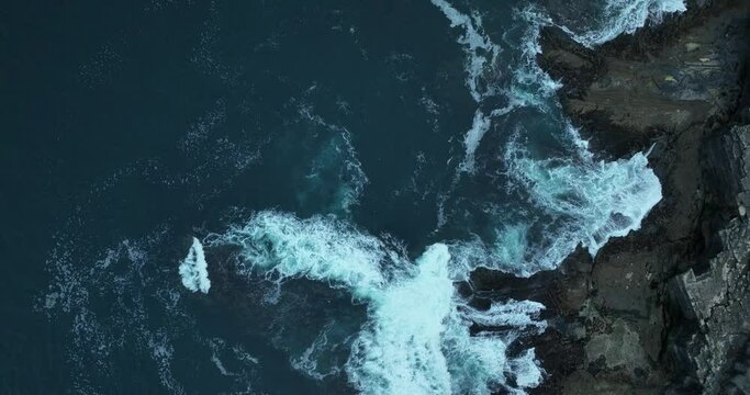 White waves of the ocean crash against the rocks 4k