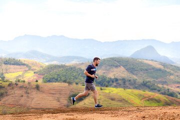 A man running outdoors amid a beautiful landscape. An image to inspire sports and wellness....