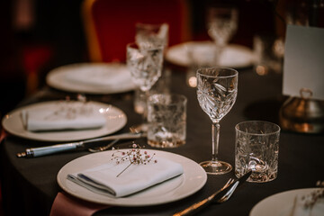 Wine glasses in the foreground. Wedding Banquet or gala dinner. The chairs and table for guests, served with cutlery and crockery.
