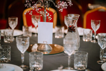 Wine glasses in the foreground. Wedding Banquet or gala dinner. The chairs and table for guests, served with cutlery and crockery.

