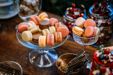 Wedding candy bar or dessert table with colorful macaroons and other sweets.
