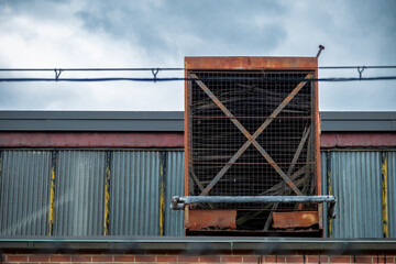 Well used industrial ventilation unti emerging from building