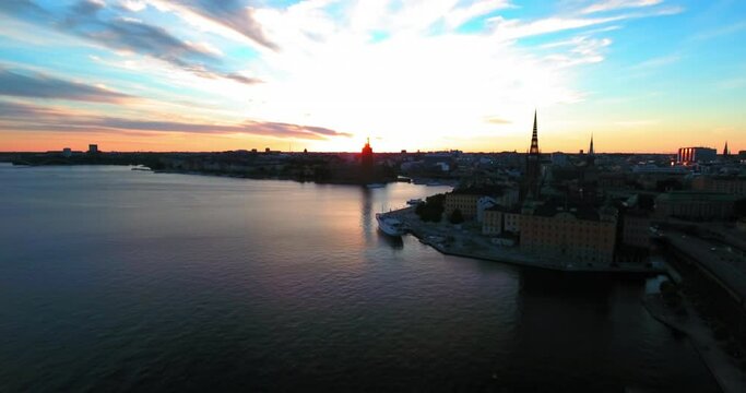 Aerial Forward Shot Of River Near Buildings In City Against Sky During Sunset - Stockholm, Sweden