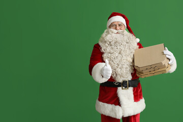 Santa Claus with pizza boxes showing thumb-up on green background