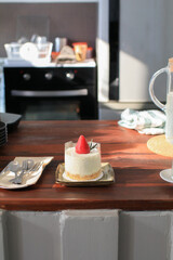Cheesecake with fresh strawberries on wooden table with sunlight. Delicious and simple cake. Homemade dessert.