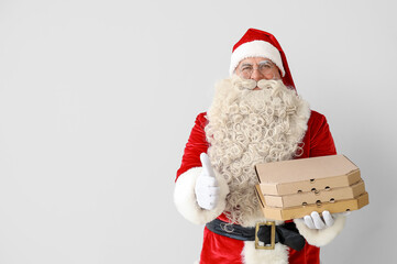 Santa Claus with pizza boxes showing thumb-up on white background