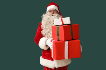 Santa Claus with Christmas gifts on green background