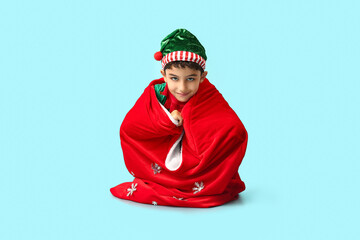 Cute little elf with Santa bag on blue background