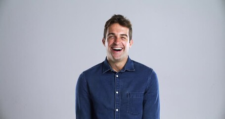 Man, face and laugh as comedy in studio grey background for crazy happy, joke meme or joy. Male person, model and portrait for emoji expression or silly goofy mood in playful, positive vibes or humor