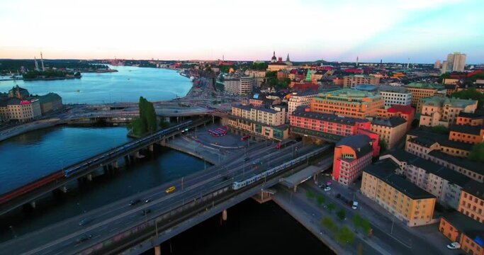 Aerial Forward Shot Of Trains And Vehicles Moving On Bridge Over Sea In City Against Sky - Stockholm, Sweden