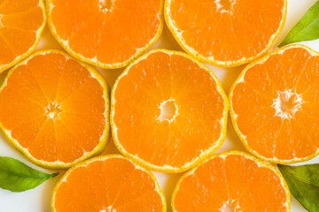 Fresh, natural round sliced tangerine with fresh green leaves,background