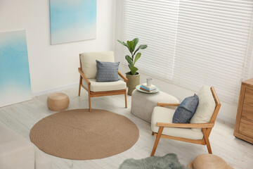 Comfortable beige armchairs, ottoman and houseplant in living room, above view. Interior design