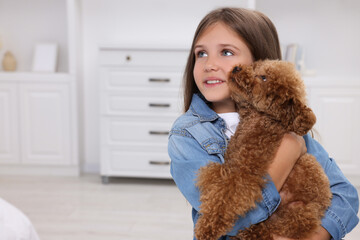 Little child with cute puppy at home, space for text. Lovely pet