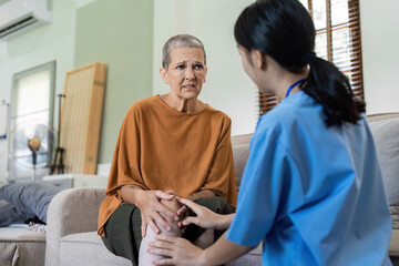 Elderly women have knee pain from osteoarthritis and have their symptoms examine by doctor for...