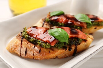 Delicious bruschettas with balsamic vinegar and toppings on white table, closeup
