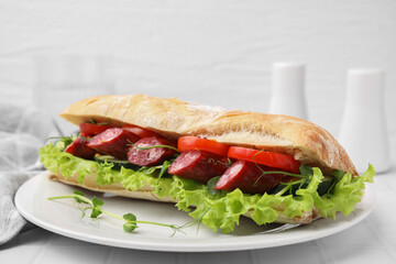 Delicious sandwich with sausages and vegetables on white table, closeup. Space for text