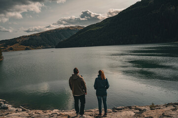 Fototapeta na wymiar A happy couple traveler enjoys in view near the mountain lake.