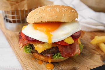 Delicious burger with fried egg on white wooden table, closeup