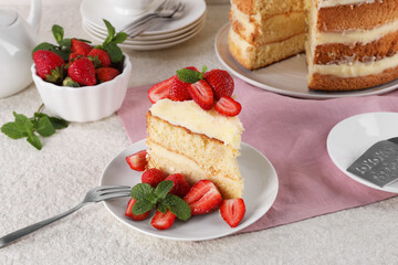 Piece of tasty cake with fresh strawberries and mint on white table