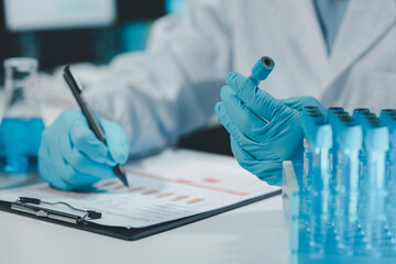 Chemist taking notes on research data, .Scientist is working in the laboratory, .Chemist is...