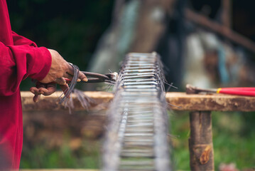 Construction Worker hands using pincer pliers iron wire. Outdoor Worker using wire bending pliers, construction work. Men hands bending cutting steel wire fences bar reinforcement of concrete work