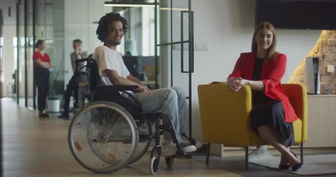 African American businessman in a wheelchair engages in a professional discussion with his colleague, addressing various business challenges and exploring solutions in an inclusive and diverse modern
