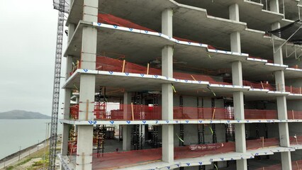 Aerial shot of a new high-rise building under construction on an overcast morning.
