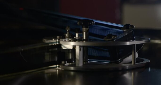70mm IMAX film runs through a feed unit in a projection booth.
