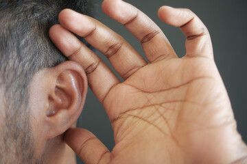 young man having ear pain touching his painful ear ,