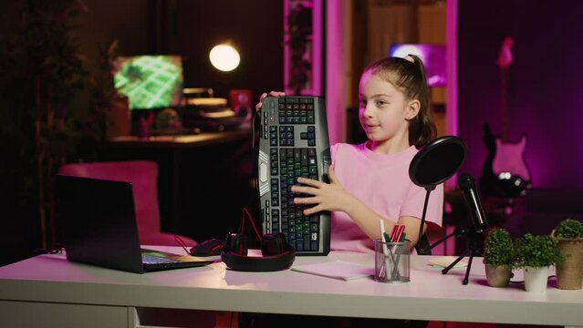 Children internet show host promoting keyboard, mouse and headphones received from sponsoring brand. Young kid star does influencer marketing, urging followers to purchase computer peripherals