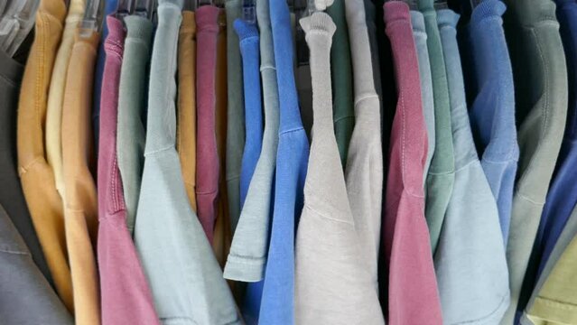 Colorful t-shirts hanging on display in retail store