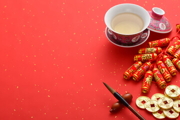 On the red background, there are teacups, coins, firecrackers, and brushes. The meaning of the text...