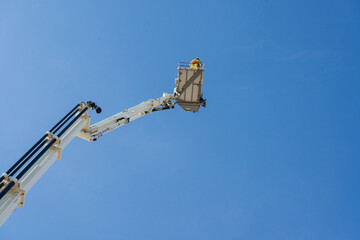 Firefighters in the fire truck crane rescue on building in the citycenter and blue sky...