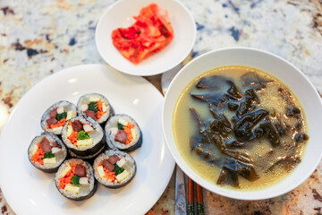 kimbap making, a cherished Korean culinary tradition. Skilled hands roll rice, vegetables, and seaweed, crafting delicious, nutritious bites for an authentic dining experience