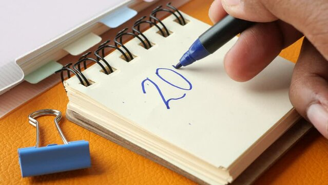 closeup of writing 2024 goals on notepad 