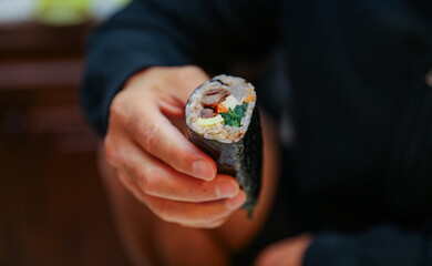 kimbap making, a cherished Korean culinary tradition. Skilled hands roll rice, vegetables, and...