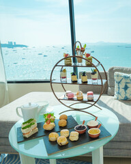 Obraz premium afternoon tea or high tea in a hotel room with bright fresh colors, a minimal style bedroom with an ocean view